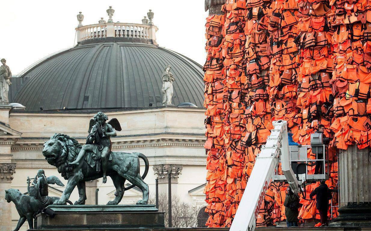 epa05158670 Workers attach life jackets used and discarded by refugees and migrants to the facade of the 'Konzerthaus' (Concert Hall) as part of an art installation by Chinese artist Ai Weiwei in Berlin, Germany, 13 February 2016. Ai Weiwei's new art project aims to remember the fate of the many refugees who died trying to reach Europe. The artist received the life vests from the Greek island of Lesbos. Berlin's Concert Hall will be the venue of the Cinema for Peace Gala held on the sidelines of the 66th annual Berlin International Film Festival on 15 February. The 'Berlinale' film festival runs from 11 to 21 February.  EPA/MICHAEL KAPPELER